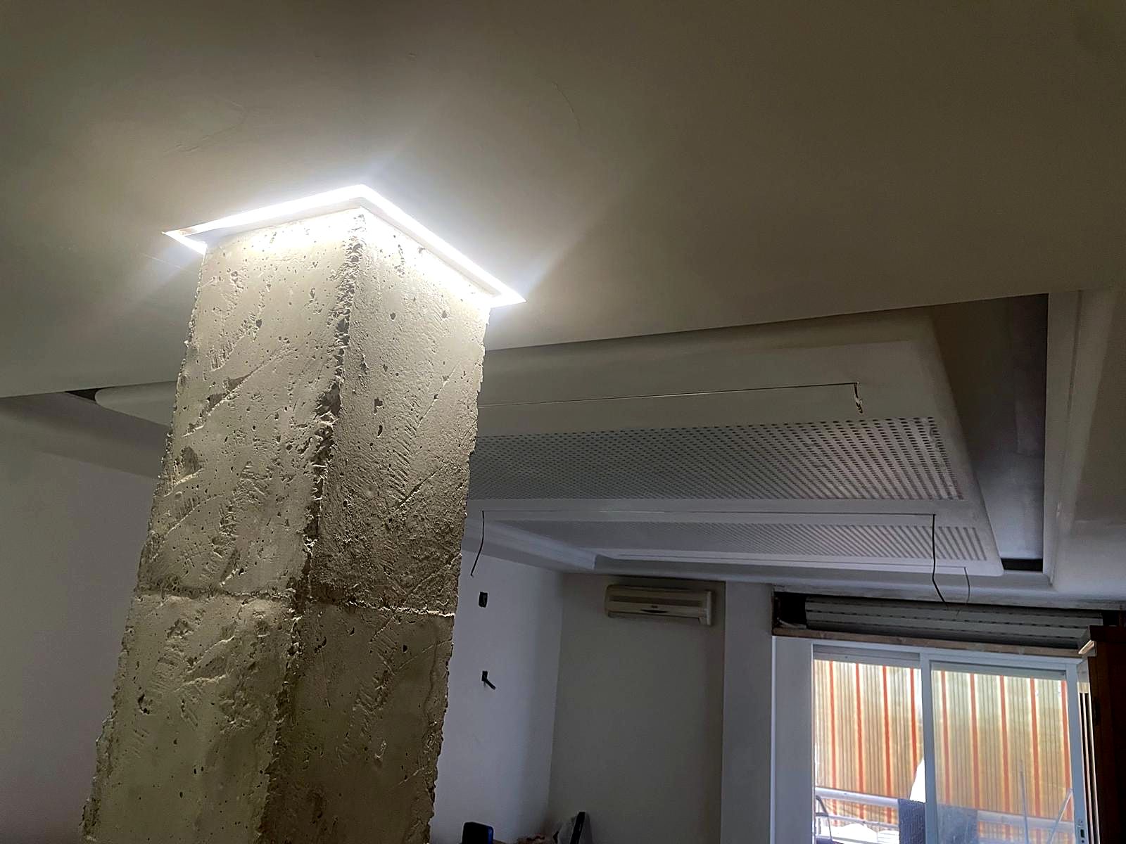 Columna de piedra con marco de luz LED en el techo de pladur