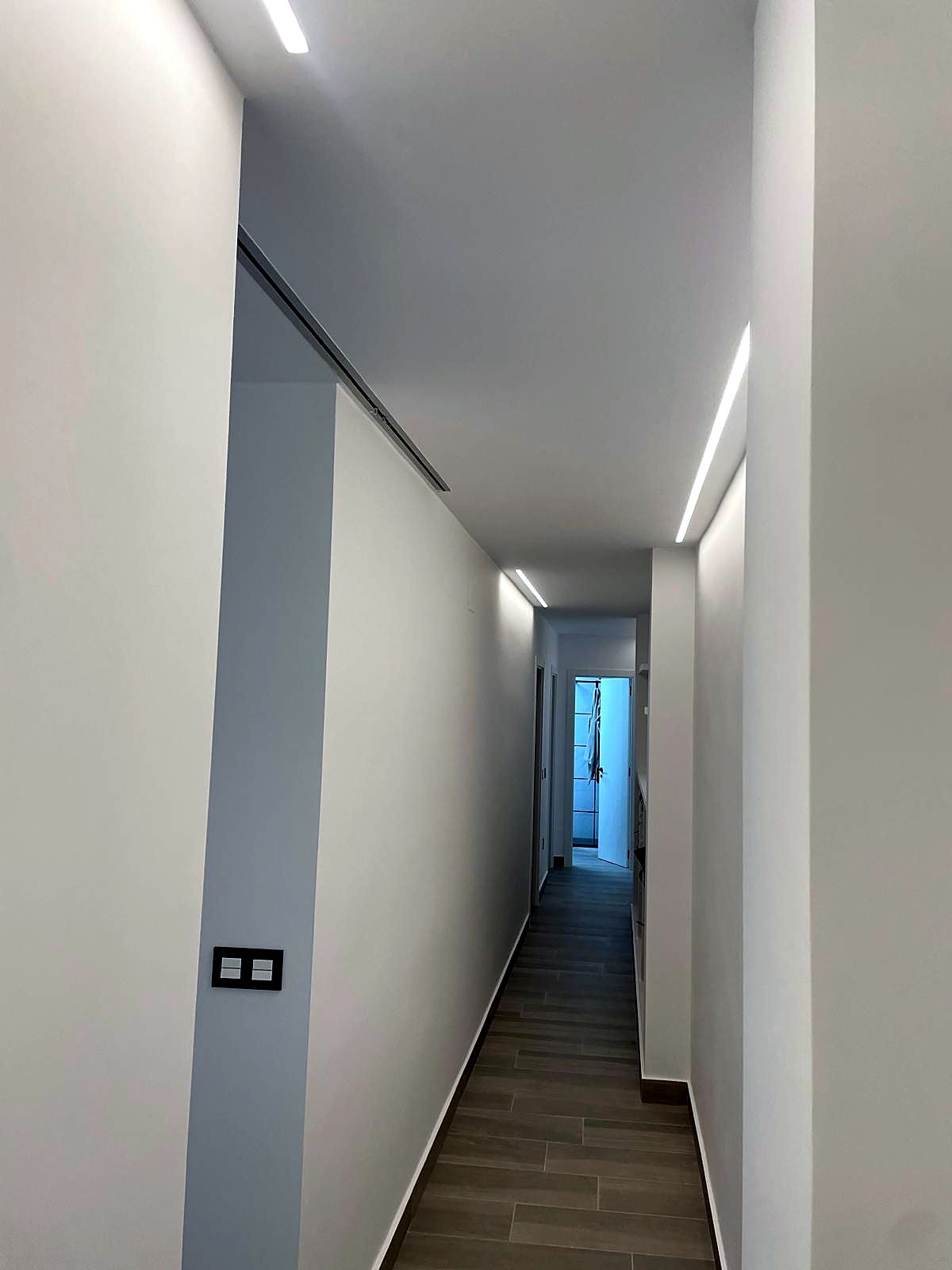 Pasillo con líneas de luz LED empotradas en el techo